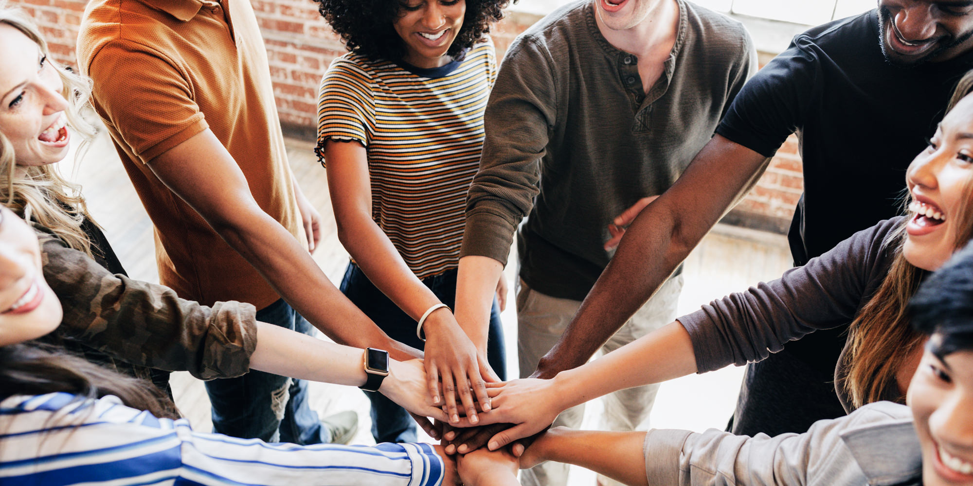 Diverse people stacking hands