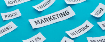 Marketing written on a piece of paper with a blue background