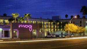 Moxy Hotel in Phoenix. Purple neon sign reads Moxy.