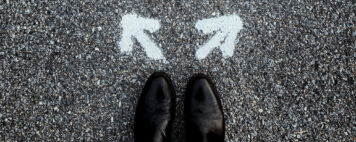 Person looking down at their shoes with two arrows pointing in different directions