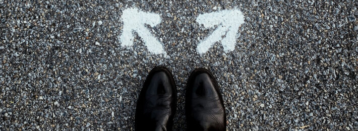 Person looking down at their shoes with two arrows pointing in different directions