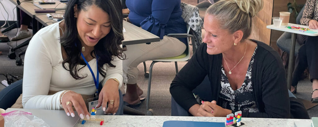 Two attendees working on a project during an Academic Impressions Workshop