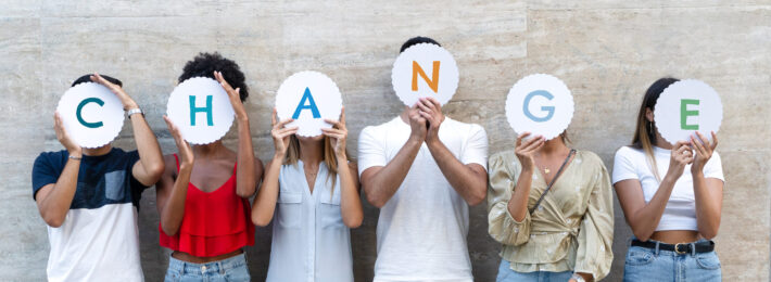 Group of people holding letter signs that spell change.